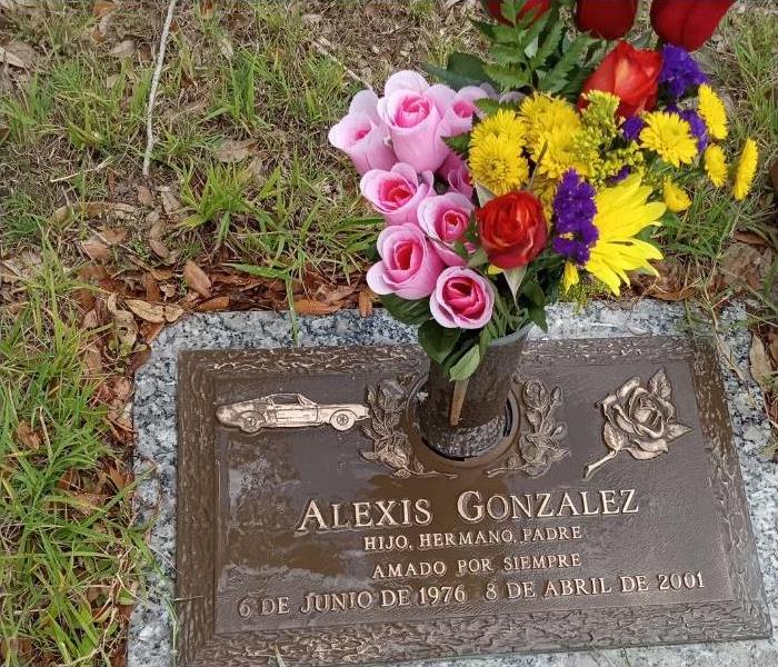 gravestone with the name Alexis Gonzalez with flowers