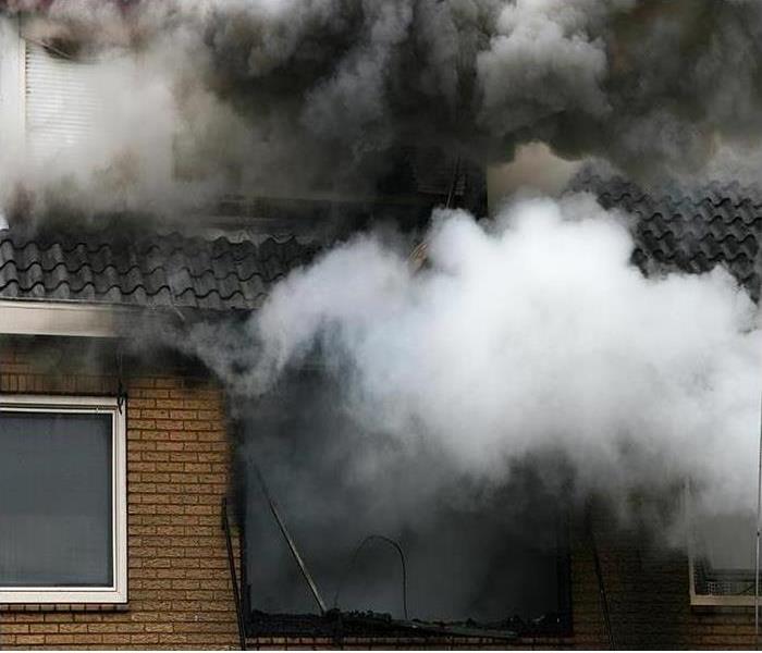 Smoke going through the roof of a brick home.